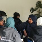 A group of Somali women talk together. They are seated in a group.